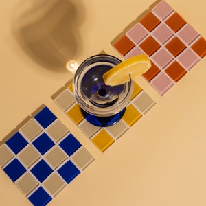 Handcrafted glass mosaic coaster featuring bold colors and a classic square layout—an eye-catching home accessory for kitchen counters, office desks, or coffee tables. This artisanal tile coaster makes a wonderful handmade gift for women who love vibrant decor, and it’s equally perfect as a Christmas gift, birthday surprise, or thoughtful thank-you.