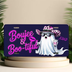May include: A navy blue license plate with the words "Boujee & Boo-tiful" in pink script. A cartoon ghost wearing sunglasses and a leopard print cowboy hat is holding a coffee cup. The word "xoxo" is written in pink.