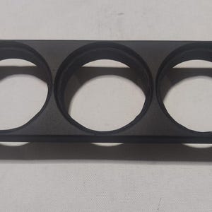 Può includere: Scatola per strumenti in plastica nera con tre aperture circolari per strumenti.
