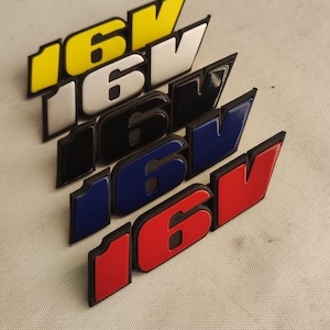 Può includere: Cinque emblemi 16V in diversi colori: giallo, bianco, nero, blu e rosso. Gli emblemi sono in plastica e hanno un effetto 3D.