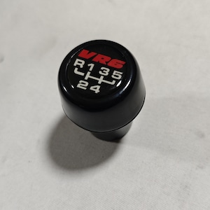 May include: Black gear shift knob with a red VR6 logo and white numbers 1, 3, 5, R, 2, and 4.