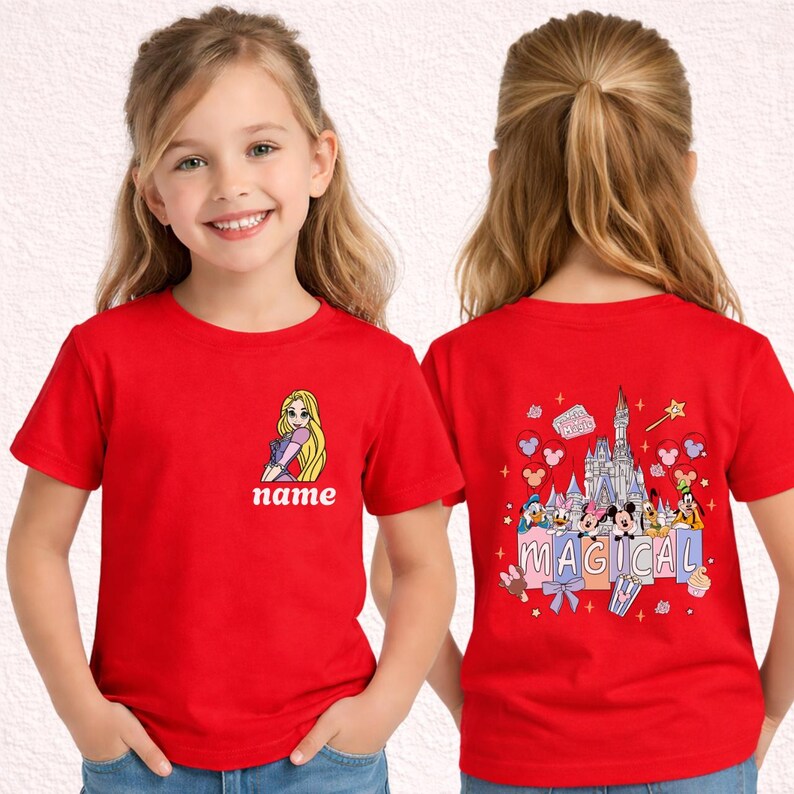 May include: Red t-shirt featuring a cartoon of a princess with long blonde hair and the word "name" on the front. The back of the shirt has a colorful graphic of a castle, characters, and the word "MAGICAL".