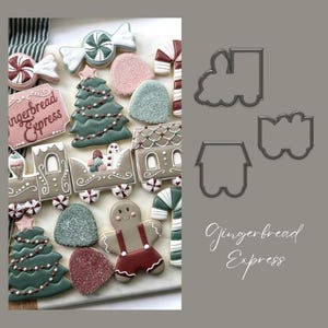 Può includere: Tagliapasta Gingerbread Express, un set di tre tagliapasta in metallo a forma di locomotiva, vagone e casa. I tagliapasta sono su uno sfondo grigio con il testo "Gingerbread Express" in bianco.