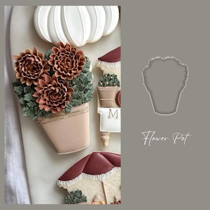 Puede incluir: Una colección de galletas decoradas con forma de maceta, calabaza y sombrilla. La galleta de la maceta presenta flores marrones y hojas verdes. El texto "Flower Pot" está escrito en cursiva.