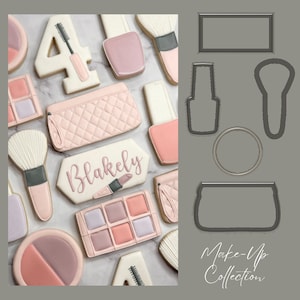 May include: A collection of decorated sugar biscuits in a makeup theme. Biscuits include a blush, eyeshadow palette, nail varnish, makeup brush, and a purse. One biscuit has the name "Blakely" written on it. The biscuits are in shades of pink, white, and grey.