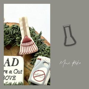 May include: A cookie decorated with a red and white rake, a gray and white can with a red circle and the word "WEEDS" inside, and a white cookie with the text "DAD you're a cut above".