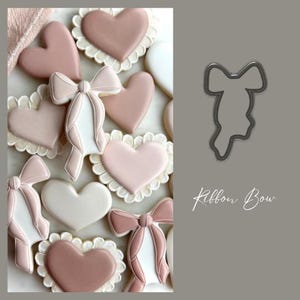 May include: A close-up of a cookie cutter shaped like a ribbon bow. The cookie cutter is made of metal and has a silver finish. The cookie cutter is on a gray background. The text "Ribbon Bow" is written in black cursive below the cookie cutter.