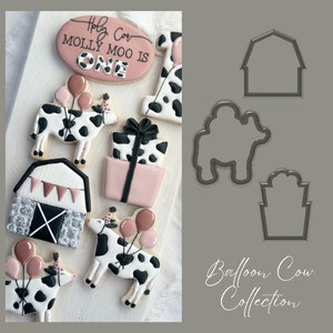 May include: A set of cookie cutters for making cow, barn, and gift box shapes. The cutters are made of metal and have a black finish. The text "Balloon Cow Collection" is written in white on a gray background.