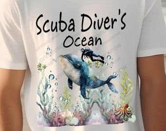 Op de afbeelding: Wit T-shirt met een afbeelding van een duiker en een walvis. De tekst "Scuba Diver's Ocean" staat op het shirt gedrukt.