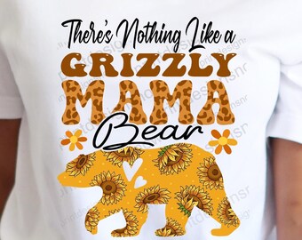 Puede incluir: Camiseta blanca con el texto "There's Nothing Like a Grizzly Mama Bear" en letras marrones. El oso es marrón con un patrón de girasol y un corazón en el centro.