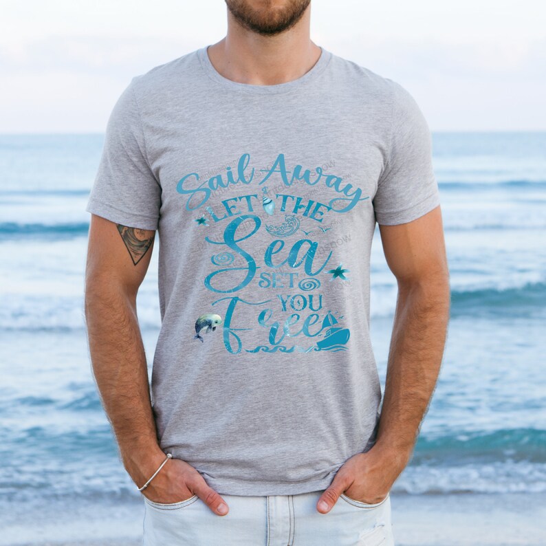 May include: A gray t-shirt with a blue graphic that says "Sail Away Let the Sea Set You Free". The graphic includes a sailboat, a dolphin, a moon, and a star.