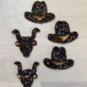May include: A collection of five embroidered patches featuring three cowboy hats and two bull heads. Each patch is crafted with dark brown and black glass beads, accented with metallic gold sequins along the brims and horns for texture.