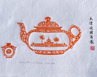 May include: An orange and white teapot with a floral design and a building inside. The teapot is on a white background with the text "Conservatory of Flowers - since 1879" and the Chinese characters "大清光绪年製" in red.
