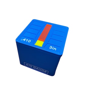 May include: A blue .410 gauge box with a 3-inch (7.6 cm) measurement. The top features a red and yellow design. The text ".410 GAUGE" is printed on the side.