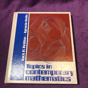 May include: A white book with a blue and red cover. The cover features a geometric design and the text "Topics in Contemporary Mathematics" by Jack R. Britton and Ignacio Bello.