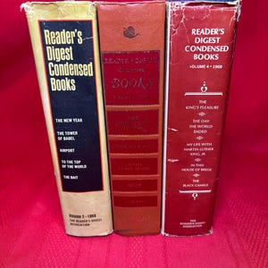 May include: Three red hardback books with gold lettering. The books are Reader's Digest Condensed Books, Volumes 2, 3, and 4. The titles of the books are listed on the spines.