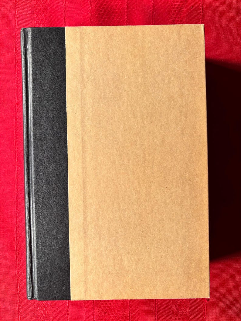 May include: A brown hardback book with a black spine.