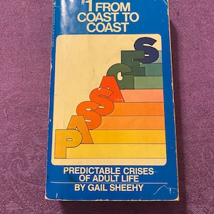 Może przedstawiać: Niebieska książka z tytułem "#1 FROM COAST TO COAST PASSAGES PREDICTABLE CRISES OF ADULT LIFE BY GAIL SHEEHY"