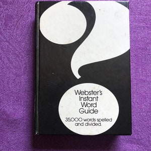 May include: A black book titled "Webster's Instant Word Guide" with white text and a large white question mark design. The book cover also features a white circle with the text "35,000 words spelled and divided."