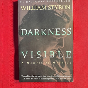 May include: A paperback book titled "Darkness Visible: A Memoir of Madness" by William Styron. The cover features a black and white photo of a person's face. The book is a #1 National Bestseller.