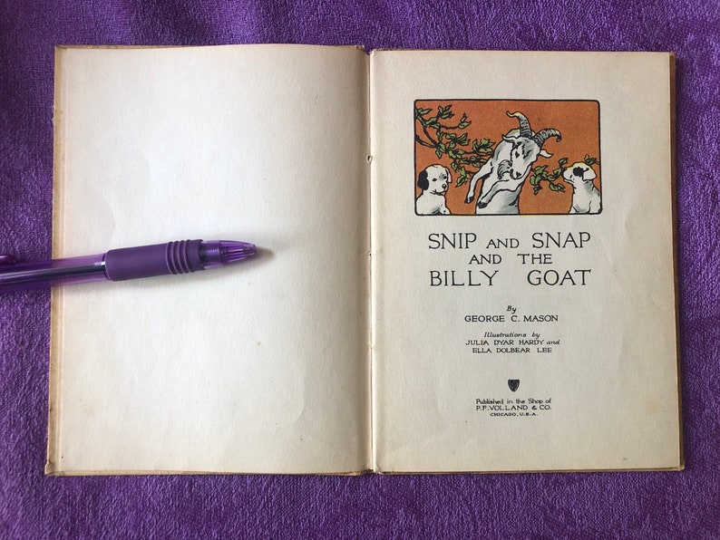 May include: An open book with a white background and a brown and orange illustration of two dogs and a goat on the right page. The title of the book is 'Snip and Snap and the Billy Goat' by George C. Mason. The book is published by P.F. Volland & Co. Chicago, U.S.A.