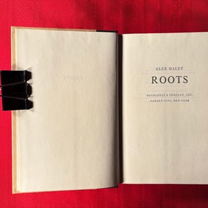 May include: A close-up of the title page of the book "Roots" by Alex Haley. The book was published by Doubleday & Company, Inc. in Garden City, New York.