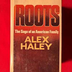 May include: A vintage paperback copy of "Roots: The Saga of an American Family" by Alex Haley. The cover features the title in bold, orange letters against a brown background.
