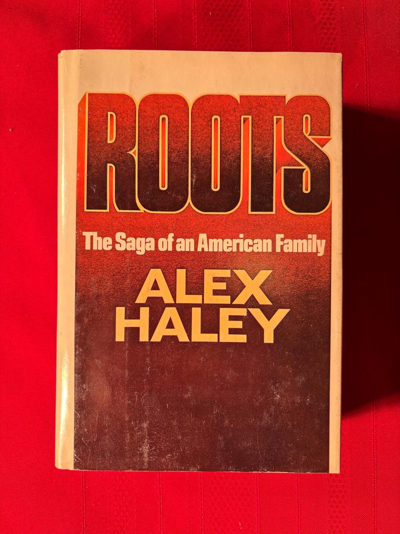 May include: A vintage paperback copy of "Roots: The Saga of an American Family" by Alex Haley. The cover features the title in bold, orange letters against a brown background.