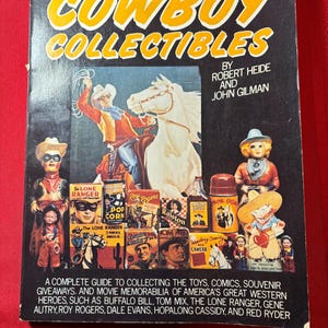 May include: A vintage book titled "Cowboy Collectibles" with a black cover and yellow lettering. The cover features a cowboy on a horse, and various collectible items. The book is a guide to collecting toys, comics, and memorabilia.