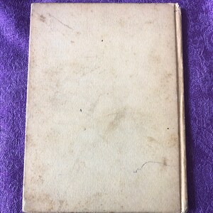 May include: A blank, off-white book cover with a slight bend in the bottom right corner.
