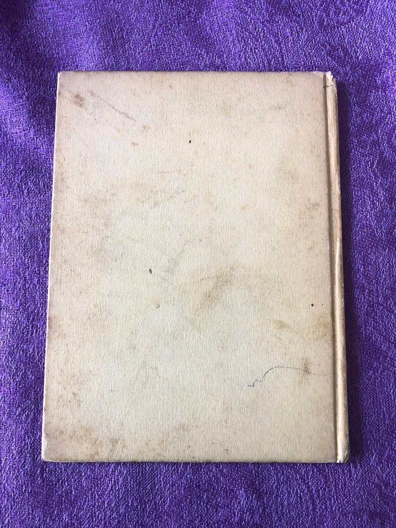 May include: A blank, off-white book cover with a slight bend in the bottom right corner.
