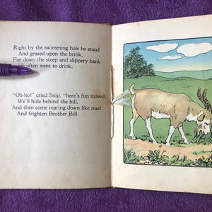 May include: An open book with a brown goat illustration on the right page. The goat is walking on a path in a green field. The left page has text that reads 'Right by the swimming hole he stood And grazed upon the brink. For down the steep and slippery bank He often went to drink. 'Oh-ho!' cried Snip, 'here's fun indeed: We'll hide behind the hill, And then come tearing down like mad And frighten Brother Bill.'