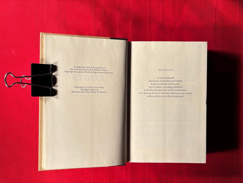 May include: A close-up of the copyright and dedication pages of a book titled "Roots" by Alex Haley. The copyright page states that the work first appeared in Reader's Digest. The dedication page reads: "It wasn't planned that "Roots" would take another year, finally encountering and writing just by chance it is being published in the Bicentennial Year of the United States. So I dedicate "Roots" as a birthday offering to my country, within which most of "Roots" happened."