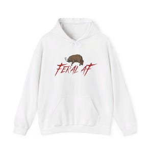 May include: White hooded sweatshirt with a red graphic of a raccoon sleeping and the text "FERAL AF" in red.