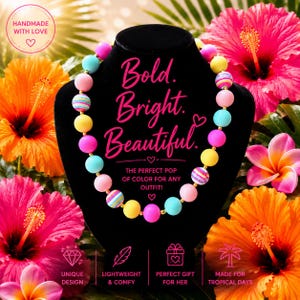 May include: A beaded necklace featuring round beads in shades of pink, yellow, blue, and multi-coloured striped patterns. The necklace is displayed on a black bust. The text on the display reads Bold. Bright. Beautiful. THE PERFECT POP OF COLOUR FOR ANY OUTFIT!