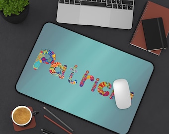 May include: A personalized mousepad with the name "Patrick" in colorful, patterned letters on a teal background. A white computer mouse rests on the pad, with a laptop and office supplies in the background.