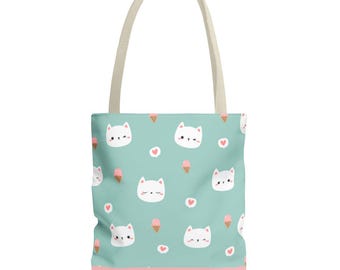 May include: A tote bag with a light teal background featuring a repeating pattern of white cat faces, pink ice cream cones, and pink hearts. The bag has a pink border at the bottom and cream-colored handles.