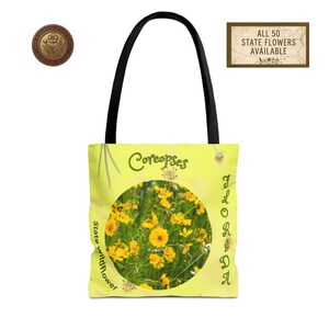 May include: A yellow tote bag with a black handle features a circular image of yellow Coreopsis flowers. The bag has the text "Coreopses" and "Florida State Wildflower". A small circular emblem and a sign that says "All 50 State Flowers Available" are also visible.