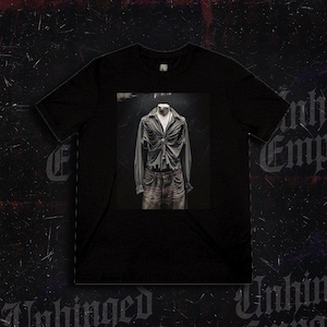 May include: Black t-shirt with a centered image of a gray button-down shirt and jeans on a mannequin. The shirt has a distressed design, and the jeans are faded. The background is dark with the word "Unhinged" in a gothic font.