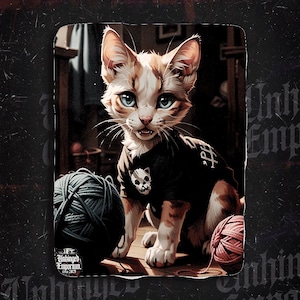 May include: A digital illustration of a cat with ginger and white fur, wearing a black shirt with a skull design. The cat sits near balls of yarn in a room with wooden furniture. The text "Unhinged Emporium" is visible.