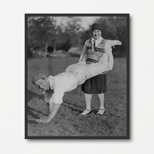 Mężczyzna i kobieta w wyścigu taczek, wydruk czarno-białej fotografii vintage, zabawny prezent fotograficzny, stare klasyczne sporty, zabawna fotografia