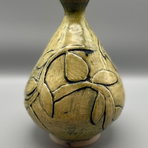 Handgeschnitzte Vase aus weißem Steinzeug. Sie ist in gelbem Seladonglas mit Kobaltoxiden im Relief glasiert.