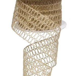May include: A roll of natural-colored burlap ribbon with an open weave design. The ribbon is on a white cardboard spool. The open weave creates a net-like appearance. This ribbon is suitable for crafts and decorations.