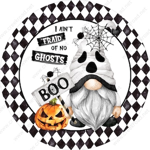 May include: A white gnome with a ghost face and a black and white checkered hat holds a sign that says "BOO" with a spider web on it. The gnome is standing on a black and white checkered background with the text "I ain't fraid of no ghosts" above the gnome.