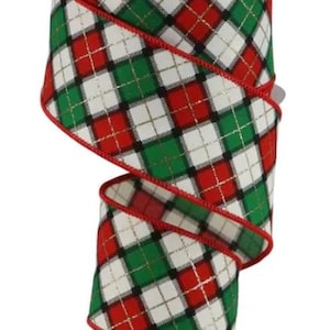 May include: A spool of wired ribbon featuring a plaid pattern in red, green, white, and black with thin gold metallic thread accents. The ribbon has a red stitched edge and is wrapped around a white plastic spool, showing a repeating diagonal design.