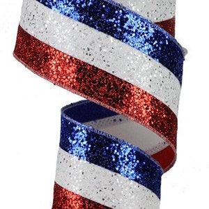 May include: Red, white, and blue glitter ribbon with a striped pattern. The ribbon is on a white spool.