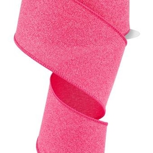 May include: A spool of pink wired ribbon with a sparkly finish. The ribbon is 2.5 inches wide and is perfect for crafting and decorating.