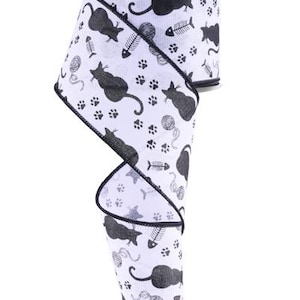 May include: White wired ribbon with a black and white print of cats, fish bones, and paw prints. The ribbon is curled and has a black edge.