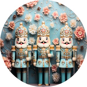 May include: Three blue and gold nutcracker figurines stand in a row against a blue background with white and pink paper flowers. The nutcrackers have gold crowns, white beards, and black mustaches.