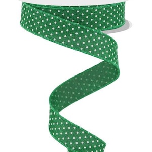 May include: Green ribbon with white polka dots. The ribbon is rolled up on a spool.